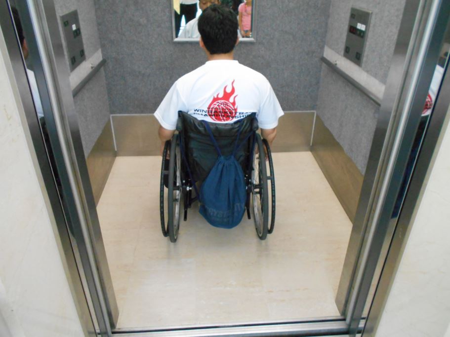 エレベーターに乗る車椅子ユーザー