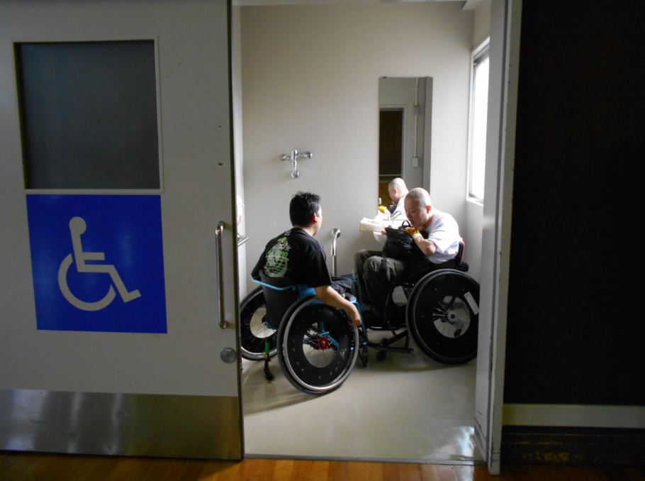 車椅子トイレの中に車椅子ユーザー2人
